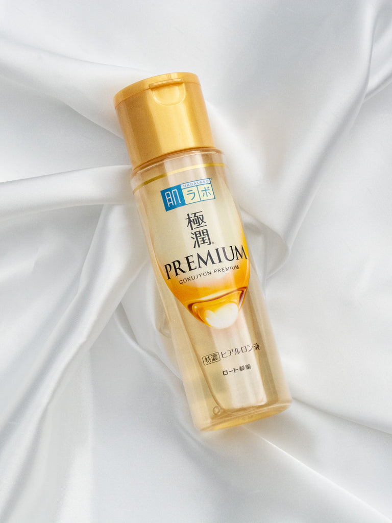 Hada Labo Gokujyun Premium Lotion 170ml bottle on satin fabric, showcasing hydrating skincare with hyaluronic acid.